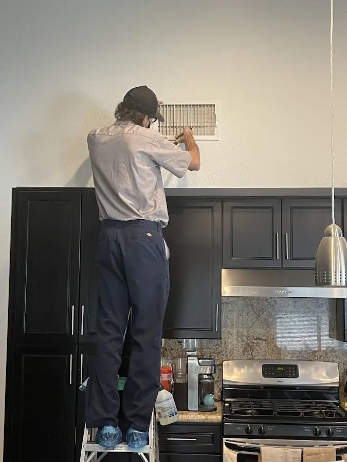 Technician inspecting an air vent during HVAC service in Lockport